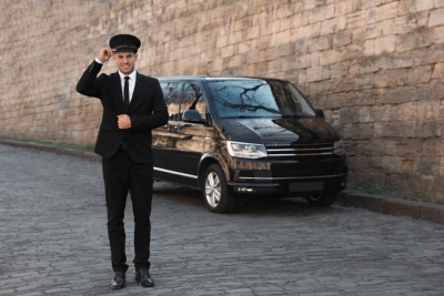 Professional driver near-luxury car on street, Chauffeur service